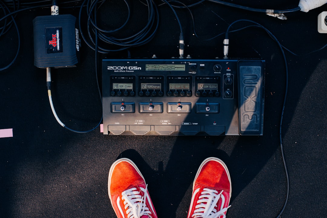 A pair of orange and white sneakers sitting on top of a black floor
